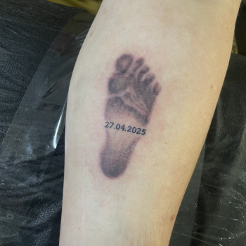 Тату на руці з відбитком ніжки та датою народження сина