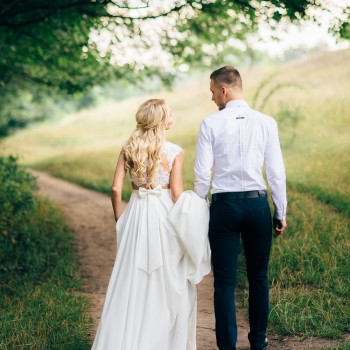 Молодожены идут по тропе под кроной деревьев: спокойный момент прогулки, легкие разговоры и природная атмосфера, фото - фотограф Дмтрий Покидин