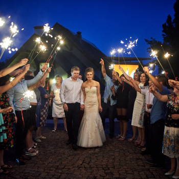 Вечерний коридор с бенгальскими огнями: гости встречают молодоженов, много эмоций и праздничный свет в кадре. Свадебный фотограф в Днепре – репортажные моменты, атмосфера вечера и живые кадры финала праздника, фото - фотограф Дмтрий Покидин