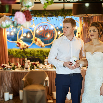 Молодожены возле празднично оформленного зала: теплый вечерний свет, декор с цветами и лампочками, момент перед ключевой частью вечера, атмосферой, деталями декора и живыми эмоциями гостей., фото - фотограф Дмтрий Покидин