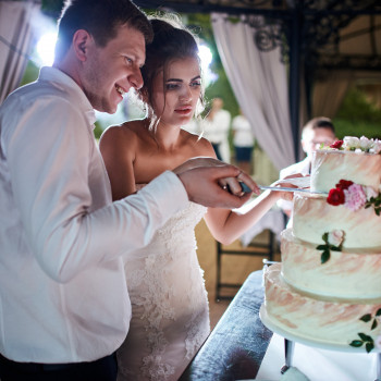 Первый разрез свадебного торта: молодожены вместе держат нож, эмоции гостей и теплый вечерний свет банкета., фото - фотограф Дмтрий Покидин