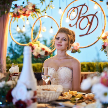 Невеста за праздничным столом в вечерней атмосфере банкета: теплые гирлянды, цветочный декор и мягкий свет в кадре., фото - фотограф Дмтрий Покидин