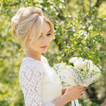 Нежный портрет невесты среди зелени: кружевное платье, мягкий солнечный свет и букет белых цветов в руках. Свадебный фотограф в Днепре — естественные кадры прогулки, чистый цвет и внимание к деталям образа., фото - фотограф Дмтрий Покидин