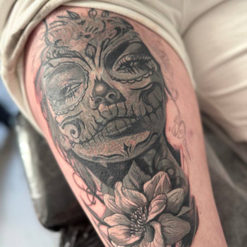 Перекриття старого татуювання тату на стегні: жіночий череп у стилі Día de los Muertos з квіткою, чорно-сірий реалізм.