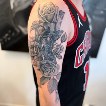 Тату на плечі: троянди з листям у чорно-сірому реалізмі.