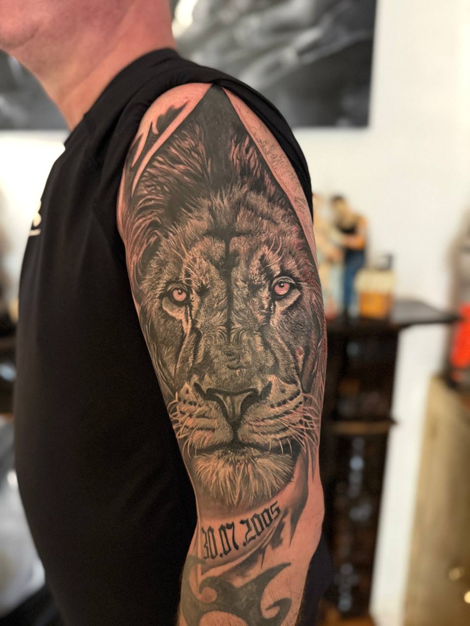 Тату на плечі: реалістичний портрет лева з датою, чорно-сірий стиль., фото - Тату салон ДІН ГИОР татуювання та пірсинг