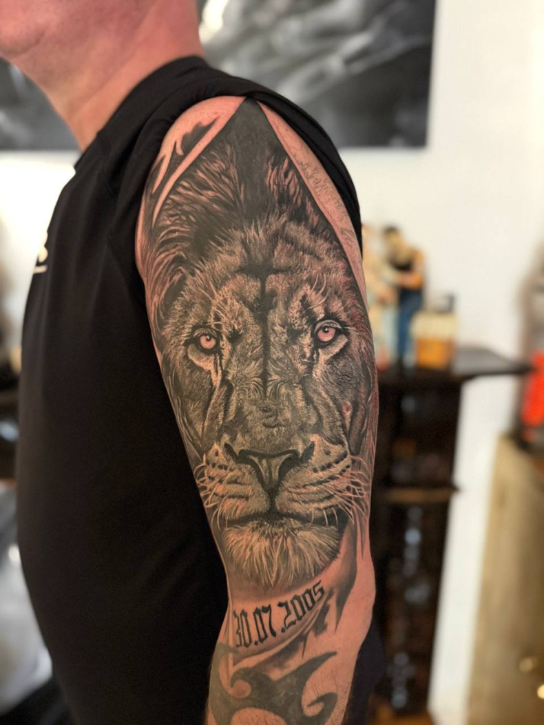 Тату на плечі: реалістичний портрет лева з датою, чорно-сірий стиль., фото - Тату салон ДІН ГИОР татуювання та пірсинг