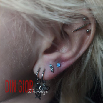 Пірсинг вуха: хелікс і кілька проколів мочки, стильні прикраси.