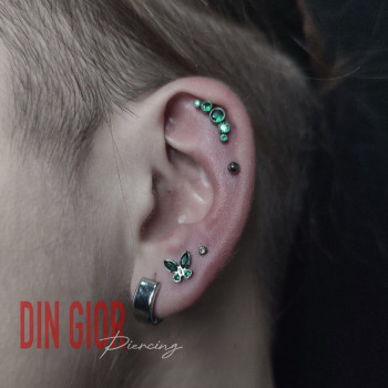 Пірсинг вуха: акуратна композиція з акцентом на хелікс та гармонійно підібрані прикраси.