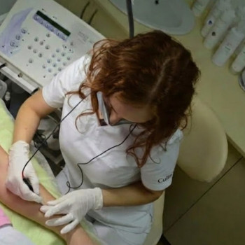 Процес електроепіляції у студії в Києві. Робота майстра на професійному обладнанні Apilus під час процедури видалення волосся.