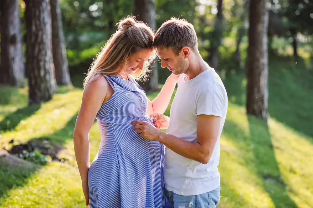 Літня парна фотосесія вагітності у парку серед дерев